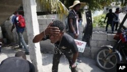 Un manifestante se lava la cara para aliviar las molestias por el gas lacrimógeno lanzado por la policía, durante una protesta para exigir la renuncia del presidente Jovenel Moïse.