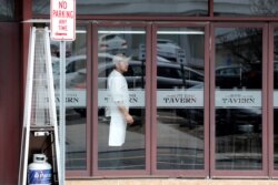 A worker looks out from a near empty restaurant on North Avenue during the coronavirus outbreak in New Rochelle, New York, March 11, 2020.