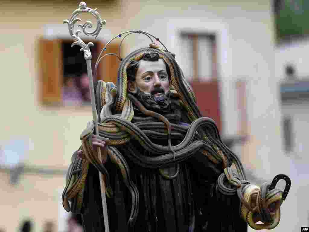 A statue of Saint Domenico covered with live snakes is carried by the faithful during an annual procession in the streets of Cocullo, a small village in the Abruzzo region, Italy.