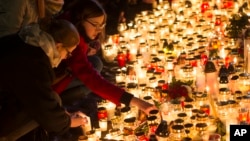 Candles are placed outside the French embassy in Vilnius, Lithuania, for the victims in Friday's attacks in Paris, Nov. 14, 2015.