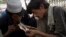 FILE - Pakistani drug addicts smoke heroin in Rawalpindi, June 26, 2013. 