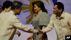 FILE - Philippine President Rodrigo Duterte, right, welcomes South Korean President Moon Jae-in, left, before the start of the Special Gala Celebration of the 50th Anniversary of ASEAN in Manila, the Philippines on Nov. 12, 2017. (AP Photo/Aaron Favila-POOL)