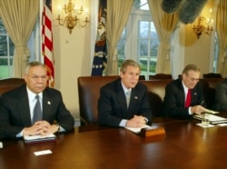Then President George W. Bush makes a statement to reporters while Secretary of State Colin Powell and Secretary of Defense Donald Rumsfeld look on following a Cabinet meeting, March 20, 2003.