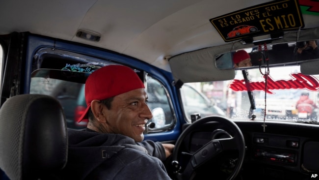 El taxista Claudio García se sienta en su Volkswagen Beetle, al que ha apodado "Gualupita" por su esposa, en el vecindario de Cuautepec, en Ciudad de México, el 21 de junio de 2024