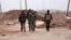 Forces loyal to Syria's President Bashar al-Assad carry their weapons as they walk along a road in the town of Tel Arn in Aleppo after capturing it from rebels November 12, 2013. 