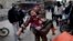 In this March 11, 2012 photo, a man carries a boy who was severely wounded during heavy fighting between Syrian rebels and Syrian Army forces in Idlib, north Syria. 
