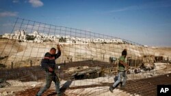 Des travailleurs transportent du matériel sur un chantier de construction dans la colonie de Maaleh Adumim, en Cisjordanie, 22 janvier 2017.