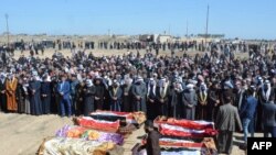FILE - Iraqi mourners pray at the funeral of eight people killed a day earlier in attacks claimed by the Islamic State (IS) group, in the al-Bou Dor village of the Salaheddin governorate north of the capital, March 13, 2021.