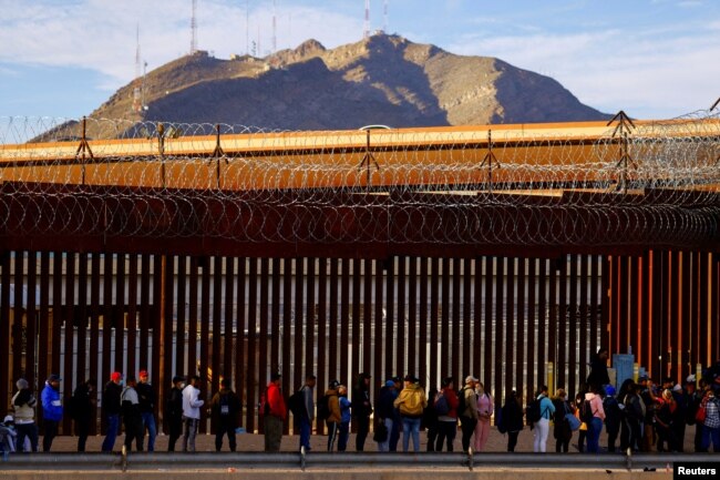 FILE - Migrants queue near the border fence, after crossing the Rio Bravo river, to request asylum in El Paso, Texas, U.S., as seen from Ciudad Juarez, Mexico January 5, 2023. (REUTERS/Jose Luis Gonzalez/File Photo)