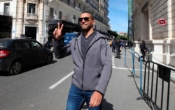 FILE - Algerian journalist Khaled Drareni gestures as he leaves the courthouse in Algiers, March 10, 2020.