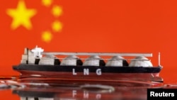 资料照片：该图显示了中国国旗前展示着一艘液化天然气运输船的模型。(2022年5月19日)