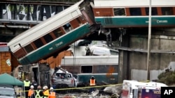 Gerbong kereta Amtrak keluar dari relnya dan terlempar ke jalanan Interstate 5 di bawahnya, di DuPont, Washington, 18 Desember 2017. Gerbong tersebut menimpa beberapa kendaraan di jalan itu, menewaskan sedikitnya tiga orang.