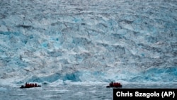 FILE - Two groups from the Poseidon Expeditions tour company look at a glacier in the Scoresby Sund, on Sept. 7, 2023, in Greenland.