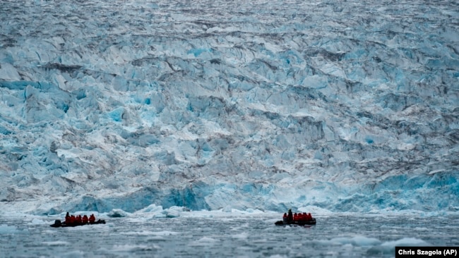 FILE - Two groups from the Poseidon Expeditions tour company look at a glacier in the Scoresby Sund, on Sept. 7, 2023, in Greenland.