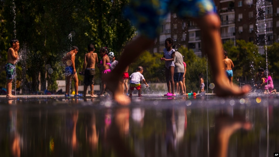 Los niños se divierten entre surtidores de agua en un parque público en Madrid, la capital de España, que experimentó la primera ola de calor del año este lunes 26 de junio de 2023.