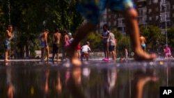 Los niños se divierten entre surtidores de agua en un parque público en Madrid, la capital de España, que experimentó la primera ola de calor del año este lunes 26 de junio de 2023.