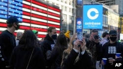 Coinbase employees gather outside the Nasdaq MarketSite during the company's IPO, in New York's Times Square, Wednesday, April 14, 2021. 