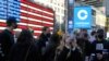 Coinbase employees gather outside the Nasdaq MarketSite in New York's Times Square, April 14, 2021, for the announcement that Wall Street will be focused on Coinbase with the digital currency exchange becoming a publicly traded company.
