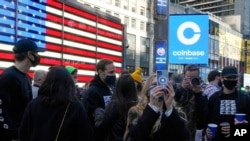 Coinbase employees gather outside the Nasdaq MarketSite in New York's Times Square, April 14, 2021, for the announcement that Wall Street will be focused on Coinbase with the digital currency exchange becoming a publicly traded company.