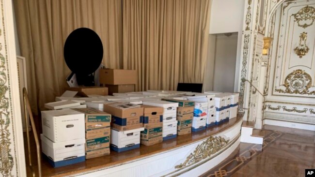Esta imagen, incluida en la acusación contra el expresidente Donald Trump, develada el 9 de junio de 2023, muestra cajas de discos almacenadas en el escenario del White and Gold Ballroom en la propiedad de Trump en Mar-a-Lago en Palm Beach, Florida.