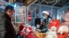 This photo taken Dec. 24, 2020, shows a vendor offering drinks to a customer at a Christmas-themed market outside of a shopping mall complex on Christmas Eve in Shanghai. 