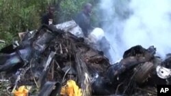 Foto yang diambil dari gambar di televisi yang ditayangkan tanggal 16 Desember ini menayangkan puing-puing helikopter yang jatuh dan terbakar di negara bagian Bayelsa di Nigeria, Sabtu (15/12). Gubernur Patrick Yakowa dan mantan penasihat keamanan nasional Nigeria, Jendral Andrew Azazi dilaporkan tewas dalam kecelakaan ini.