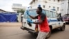 Un homme oriente les ambulances à leur arrivée à l'entrée de l'hôpital Connaught à Freetown, en Sierra Leone, le 16 août 2017.