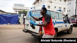 Un homme oriente les ambulances à leur arrivée à l'entrée de l'hôpital Connaught à Freetown, en Sierra Leone, le 16 août 2017.