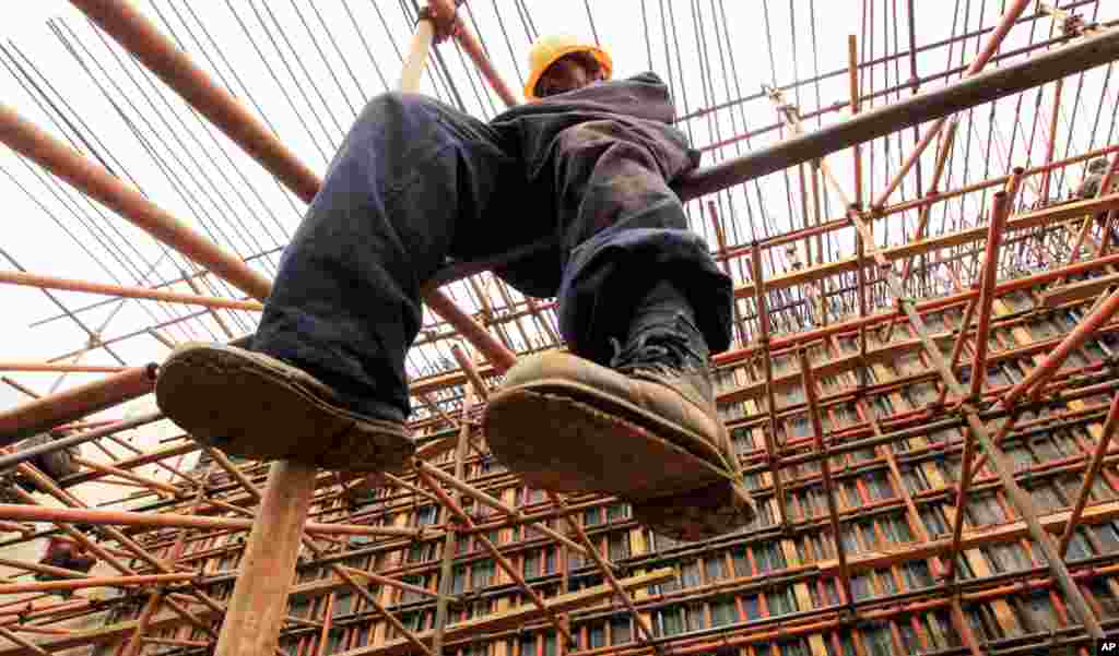 A construction worker erects scaffolding on a new bridge along the Nairobi-Thika highway project, under construction near Kenya's capital Nairobi, September 13, 2010. The road, built by China Wuyi, Sinohydro and Shengeli Engineering Construction group, is