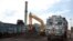 FILE- Domestically produced petroleum coke is loaded onto a truck to be transported to factories, at a railway station in Rampur, about 210 kilometers (130 miles) from New Delhi, India, July 14, 2017.