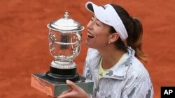 Spain's Garbine Muguruza holds the trophy after winning the final of the French Open tennis tournament against Serena Williams of the U.S. in two sets 7-5, 6-4, at the Roland Garros stadium in Paris, France, June 4, 2016. 