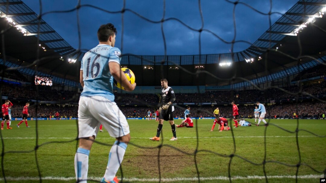 Pemain Manchester City, Sergio Aguero mengambil bola dari net setelah sebuah gol dari kawan satu timnya Yaya Toure dalam pertandingan dengan Cardiff City, Januari. (AP/Jon Super)