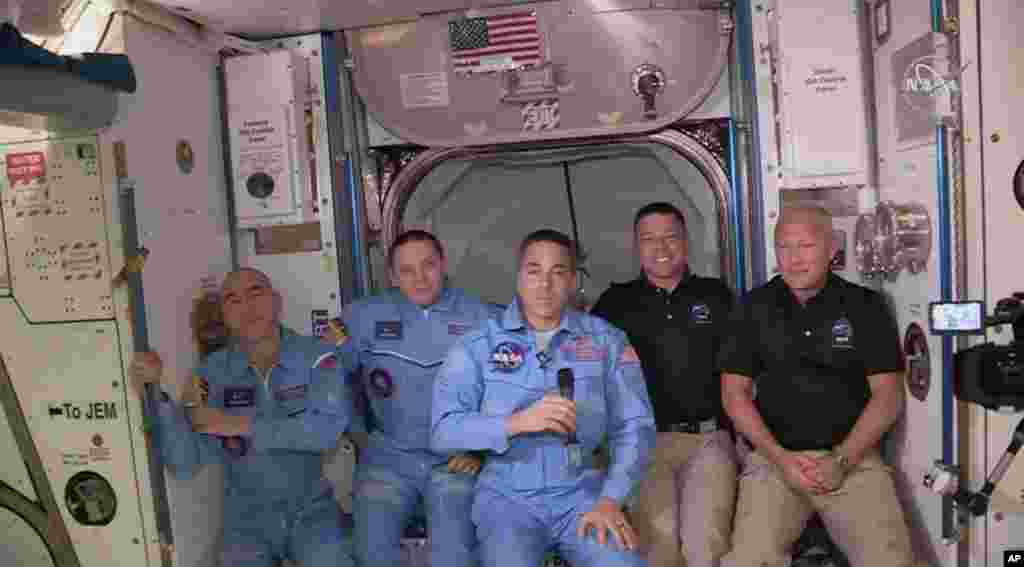  Esta foto proporcionada por la NASA muestra a Bob Behnken y Doug Hurley, a la derecha, uni&#233;ndose a la tripulaci&#243;n en la Estaci&#243;n Espacial Internacional.