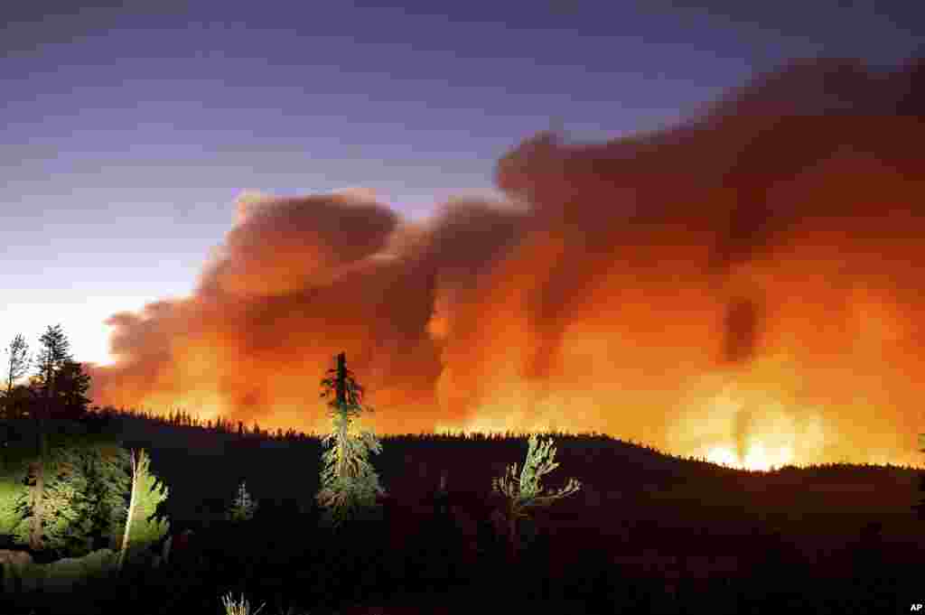 Seen in a long camera exposure, the Caldor Fire burns, Aug. 29, 2021, in Eldorado National Forest, California.