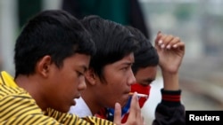 Sejumlah pelajar sedang merokok di pinggir rel kereta, di Jakarta, 24 Mei 2012. (Foto: Beawiharta/Reuters, arsip)