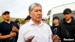 FILE - Kyrgyz former President Almazbek Atambayev, who was stripped of legal immunity after a parliamentary vote, and his supporters attend a meeting with journalists in the village of Koy-Tash near Bishkek, Kyrgyzstan, June 27, 2019. 