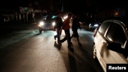 People walk on a street during a blackout in Caracas, Venezuela, Dec. 2, 2013.