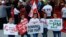 Lebanese women hold placards supporting the outgoing Lebanese Prime Minister Saad Hariri to return from Saudi Arabia during the Beirut Marathon in Beirut, Lebanon, Nov. 12, 2017. 