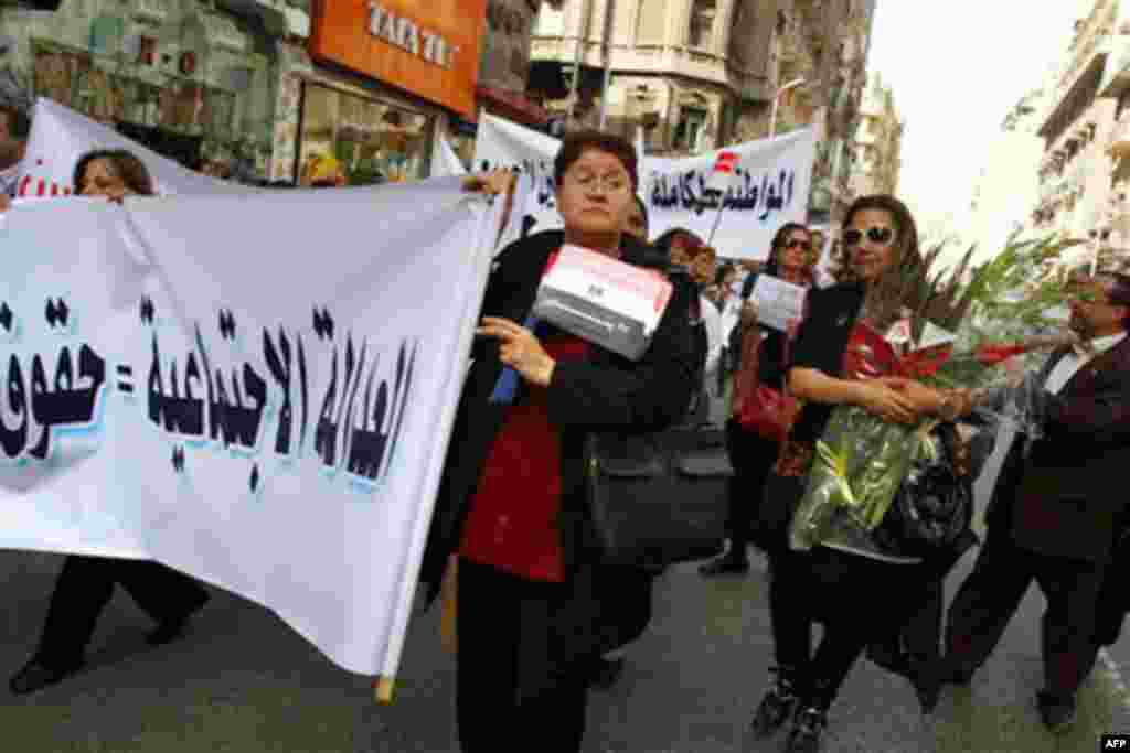 Egyptian women carry banners in Arabic that read:"Social justice," as they march to Cairo's central Tahrir Square to celebrate International Women's Day, Tuesday, March 8, 2011. A protest by hundreds of Egyptian women demanding an end to sexual harassment