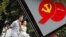 A couple walks past an advertisement to celebrate the upcoming 90th anniversary of the founding of the Communist Party of China on July 1, in Shanghai, China, June 22, 2011.