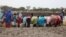 Women who recently crossed over from Sudan's Blue Nile state with little food or water fill jerry cans at a watering hole called km 18, June 20, 2012 (Hannah McNeish/VOA)