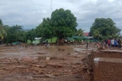 Warga melihat kerusakan di desa yang dilanda banjir bandang di Flores Timur, Minggu, 4 April 2021. (Foto: AP)