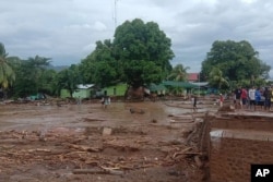 Warga melihat kerusakan di desa yang dilanda banjir bandang di Flores Timur, Minggu, 4 April 2021. (Foto: AP)