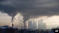 FILE - Smoke rises from a Moscow power station with Moscow's City Center skyscrapers visible in the background in Moscow, Russia.