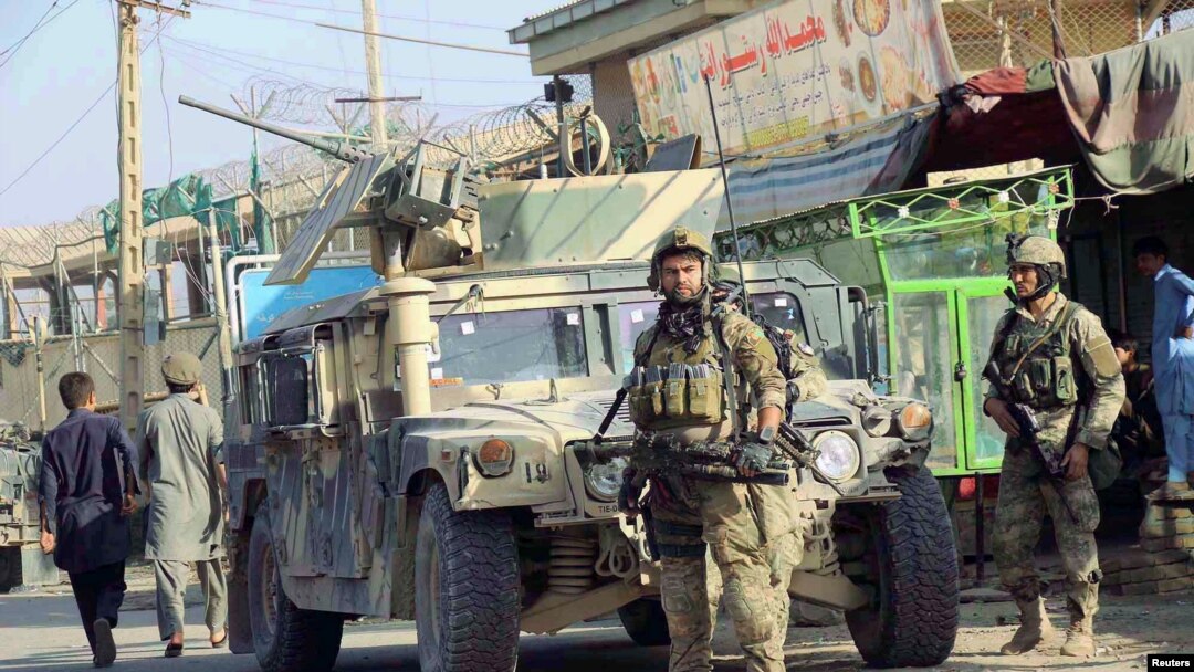 Pasukan keamanan Afghanistan berjaga di depan kendaraan lapis baja mereka di Kunduz, Afghanistan (4/10). 