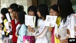 A group of unemployed Chinese graduates hold signs offering themselves as tutors, along a street in Shenyang, northeast China's Liaoning province.