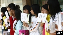 資料照片- 2007年瀋陽街頭，一群畢業後找不到工作的大學生站在街頭，手舉推薦自己可為孩子提供家教的紙牌。