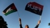 Seorang pria mengacungkan bendera Palestina dan Sandinista saat peresmian jalan Gaza untuk mendukung rakyat Palestina, di pusat Kota Managua yang bersejarah, di Nikaragua, 30 Januari 2024. (Foto: Oswaldo Rivas/AFP)