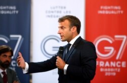 French President Emmanuel Macron delivers a speech on environment and social equality to business leaders on the eve of the G-7 summit, in Paris, Aug. 23, 2019.