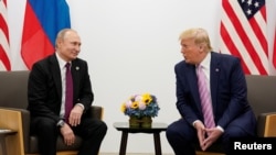 Presiden Rusia Vladimir Putin dan Presiden AS Donald Trump berbicara selama pertemuan bilateral di KTT para pemimpin G20 di Osaka, Jepang, 28 Juni 2019. (Foto: Reuters / Kevin Lamarque)